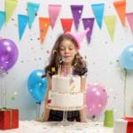 Little girl blowing candles on a birthday cake