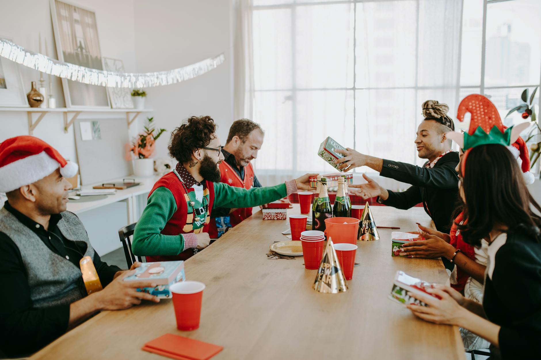 Pracownicy różnych narodowości wymieniają się prezentami na firmowej wigilii