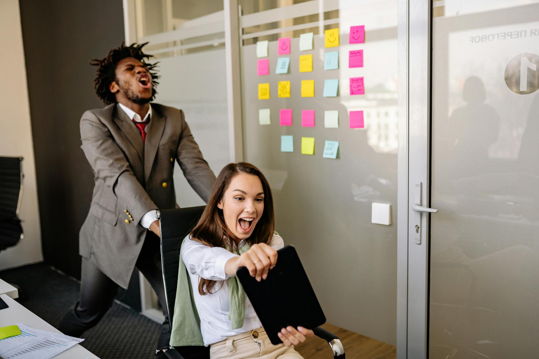 Integracja nowych pracowników poprzez mobilne escape roomy krok po kroku Zespół współpracowników śmieje się wspólnie w biurze podczas integracji